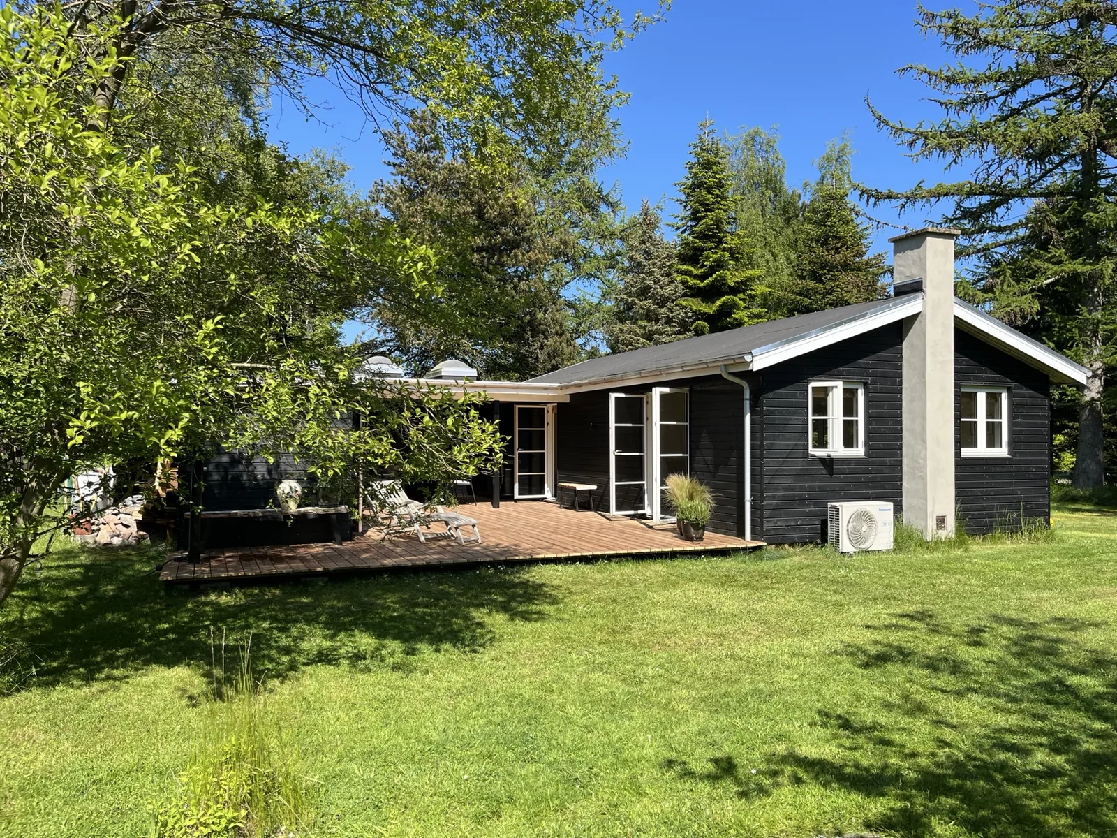 Sommerhuset og haven i solskin